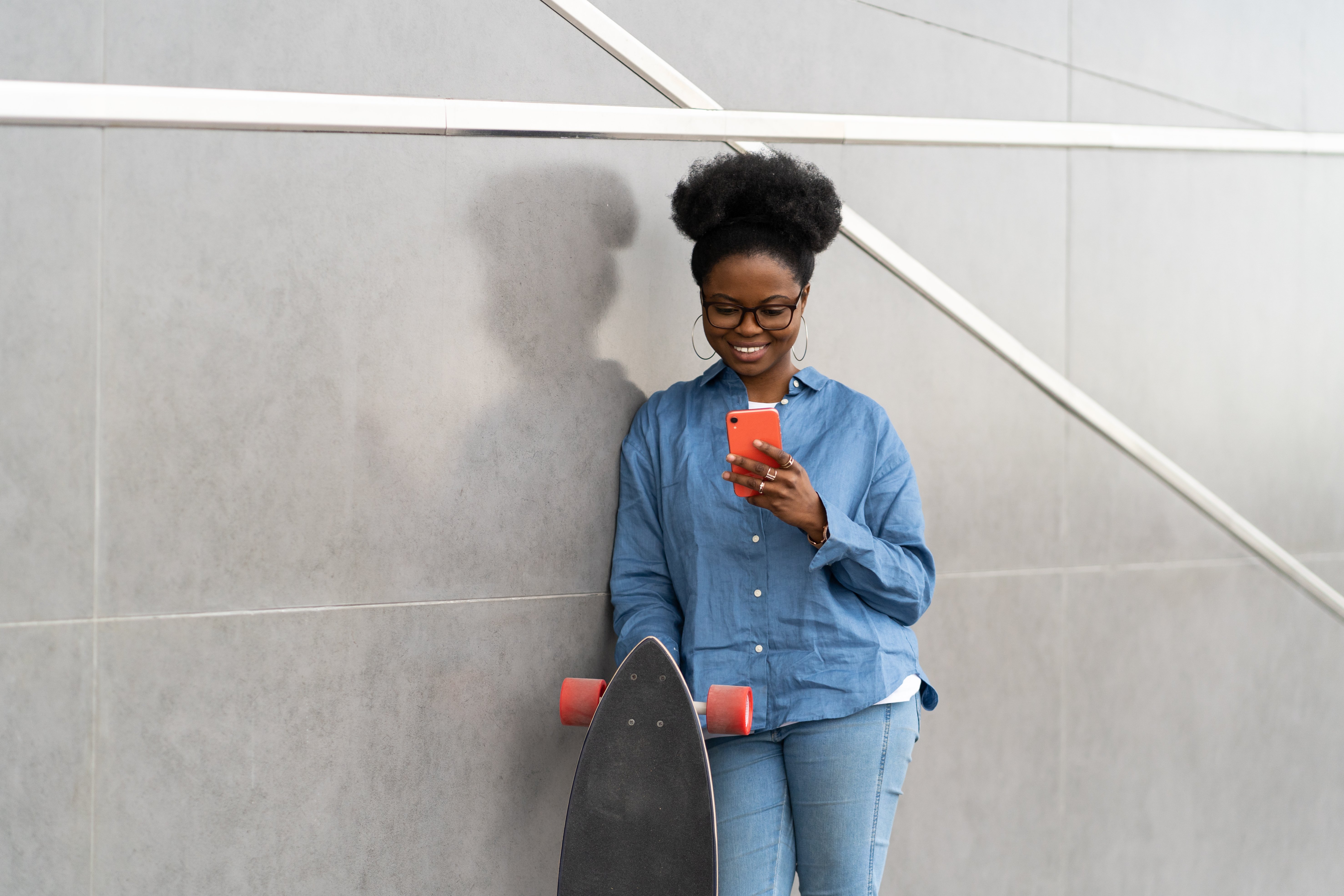 afro-american-girl-texting-or-browsing-in-smartpho-KGM7F4M