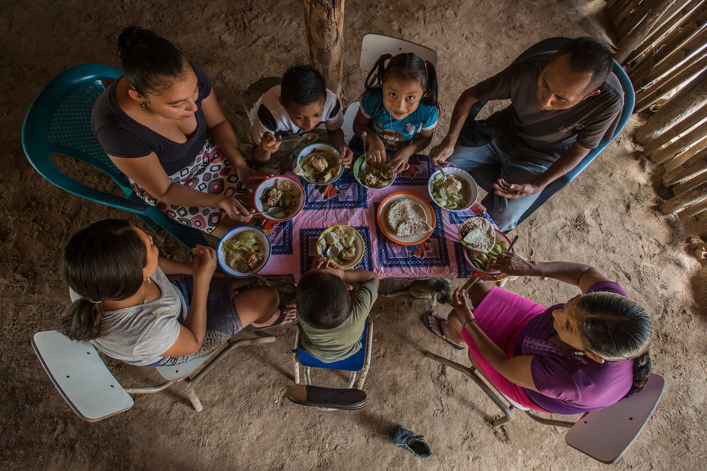  48 / 5000 Resultados de traducción familia comiendo en una mesa sencilla en una casa de madera 